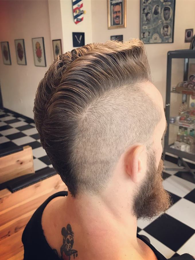 Undercut desligado com topo volumoso e barba cheia — visto de trás