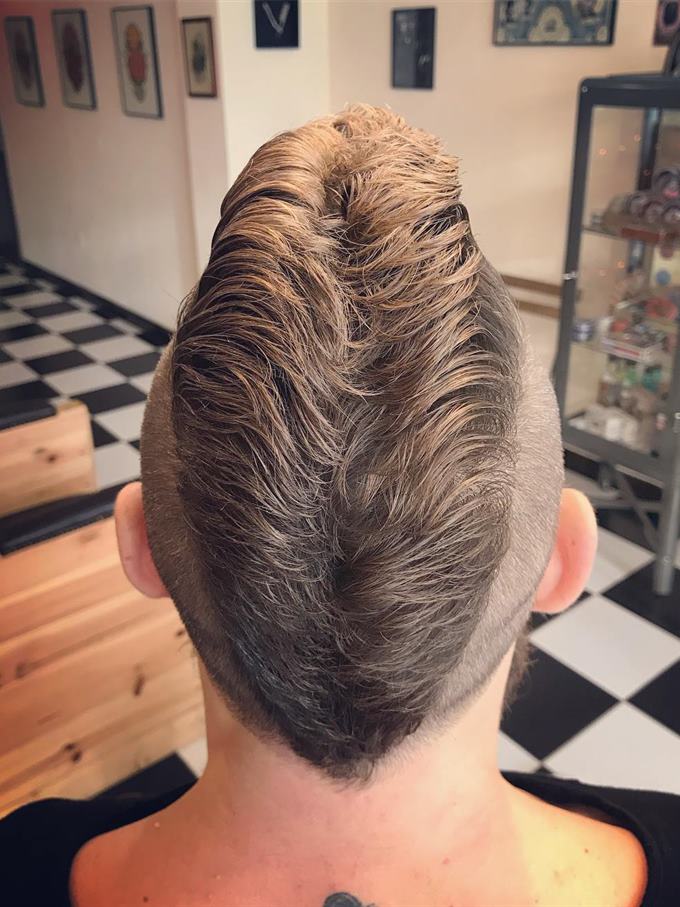 Undercut desligado com topo volumoso e barba cheia — de cima